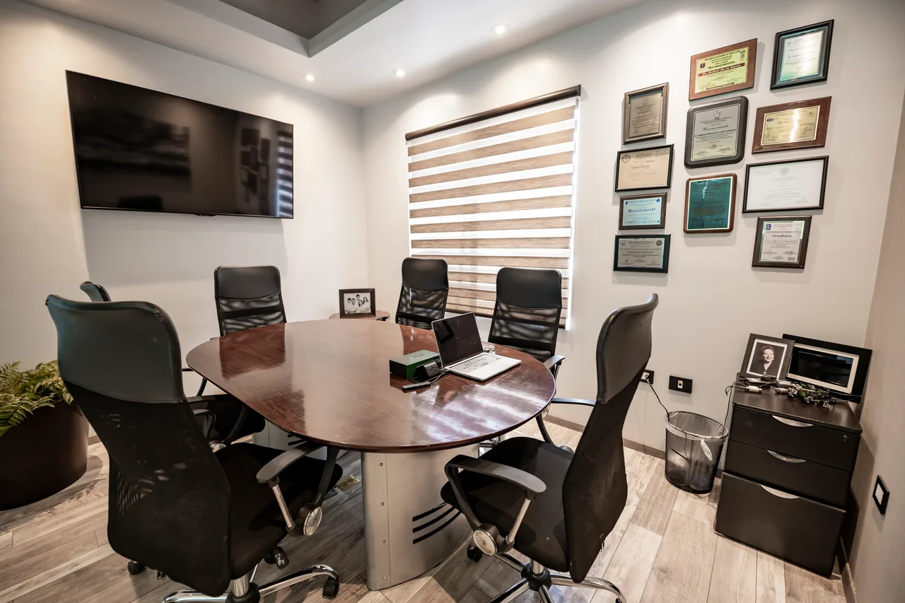 Consultorio de consulta de Klida, con pantalla y muro de certificaciones