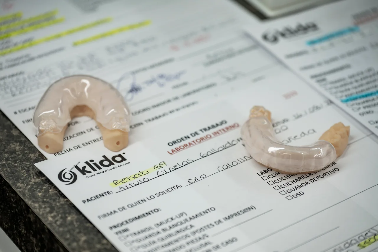 Orden de trabajo del laboratorio de Klida junto a los modelos de la pieza